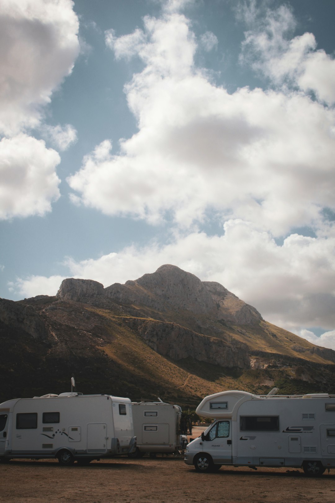 a-couple-of-trucks-parked-next-to-a-mountain-bdcjybwep6u